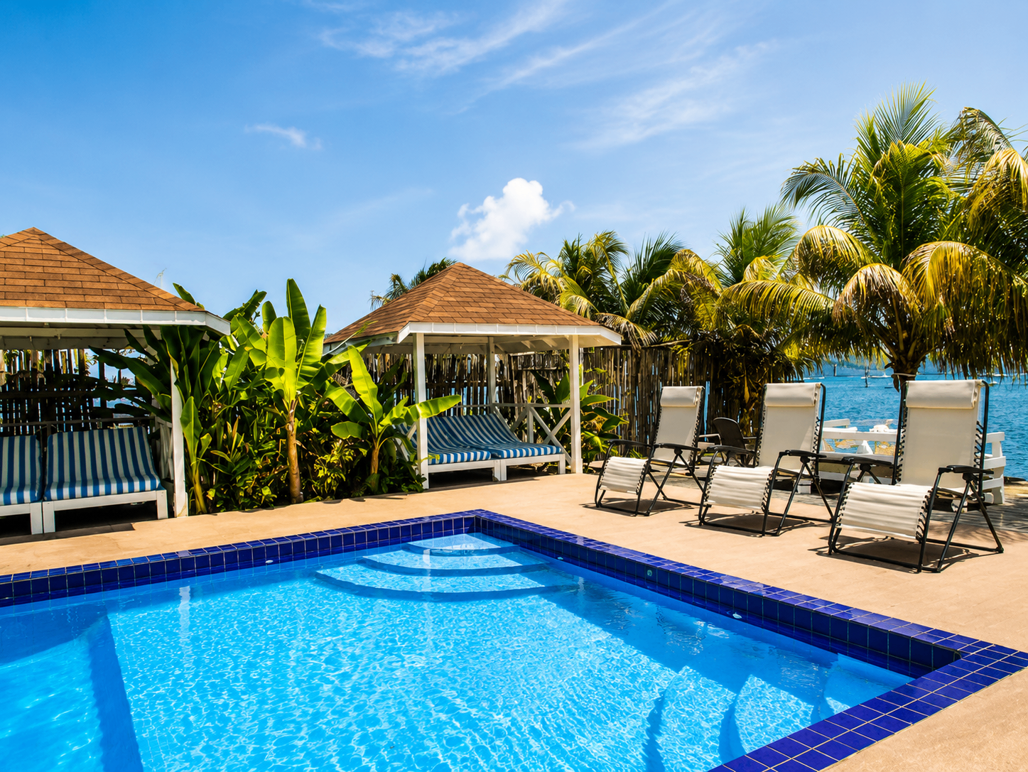 Pool and loungers on the waterfront terrace at Point Bay Resort